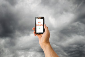 hand with a phone searching for signal with a stormy sky